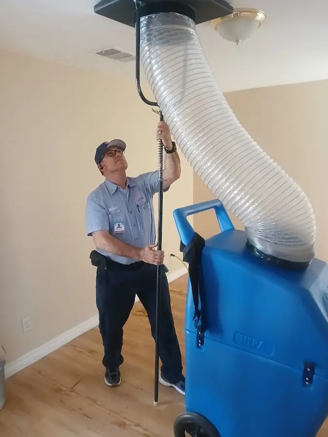 Furnace Tune-Up technician using HEPA equipment in Handy